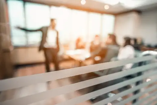 Formation gestion des conflits : intervenant animant une séance de médiation auprès d'une équipe en salle de réunion en entreprise