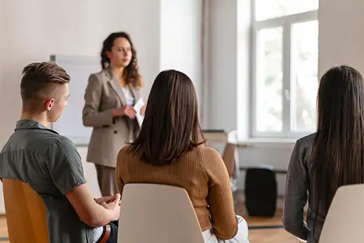 Formation prévention du harcèlement au travail : intervenante face à un groupe de participants en cercle dans une salle de formation