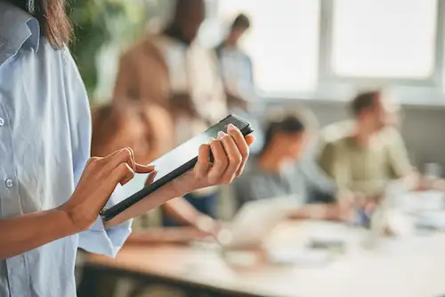 Formation prévention des risques psychosociaux : professionnelle consultant une tablette lors d'une session de travail en équipe en entreprise