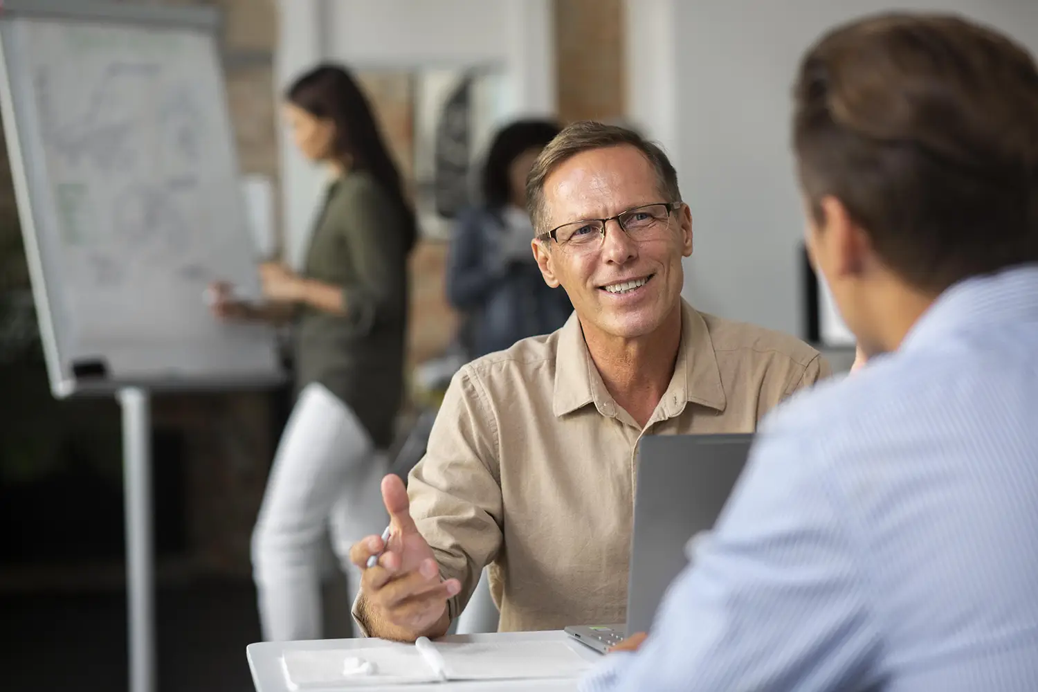 Séance de coaching pour dirigeants entre un coach expérimenté et un cadre supérieur dans un environnement professionnel confidentiel